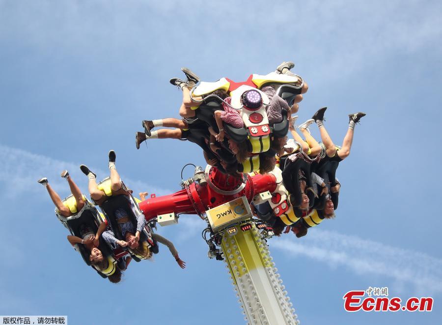 Visitors experience a thrill ride during Oktoberfest in Munich, Germany. Thousands of visitors, many of them dressed in traditional lederhosen or dirndl corseted dresses, descended on Munich on Saturday for the start of the annual Oktoberfest, the world’s largest beer festival. Oktoberfest is the world\'s largest beer celebration and typically draws over six million visitors over its three-week run. Oktoberfest includes massive beer tents, each run by a different Bavarian brewer, as well as amusement rides and activities.  (Photo/Agencies)