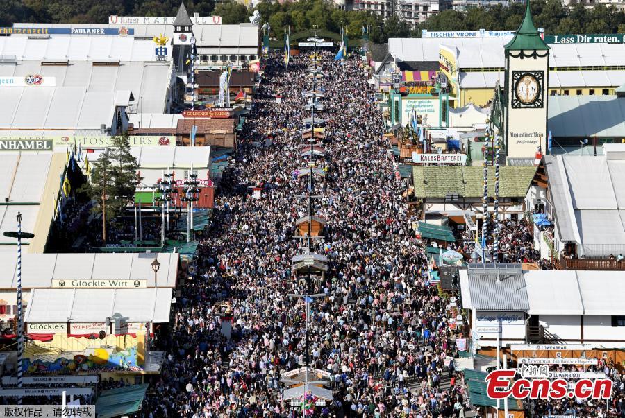 Visitors cheer with beers during the 185th Oktoberfest in Munich, Germany. Thousands of visitors, many of them dressed in traditional lederhosen or dirndl corseted dresses, descended on Munich on Saturday for the start of the annual Oktoberfest, the world’s largest beer festival. Oktoberfest is the world\'s largest beer celebration and typically draws over six million visitors over its three-week run. Oktoberfest includes massive beer tents, each run by a different Bavarian brewer, as well as amusement rides and activities.  (Photo/Agencies)