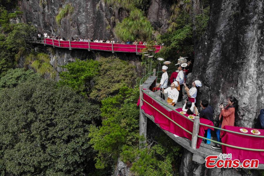 Chefs show stunt skills with kitchenware at a restaurant built on a cliff at Longquan Mountain in Zhejiang Province, Sept. 27, 2018. The restaurant 1,600 meters above sea level allows customers to dine on suspended plank roads while enjoying great views of the mountain. Longquan is the highest peak in the Yangtze River Delta. (Photo: China News Service/Yang Yong)