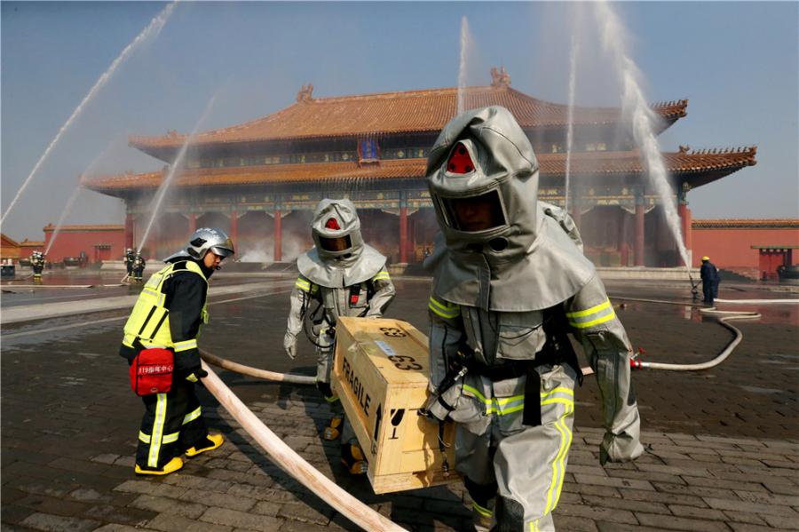 Drills are staged frequently at the Palace Museum in Beijing, where a team is stationed by the east gate to keep watch for fire in turn 24 hours a day. (Photo/CHINA DAILY)

Tests are held every week. Firefighters have to run more than 50 meters within 13 seconds carrying three rolls of 20-meter-long standpipe hoses and connecting them.

Strict practice is essential to remaining vigilant.

Firefighters stationed in residential areas may be called out to fires every day. However, since the Tiananmen Fire Squadron was set up in 1970, there have been no major fires within its 3.74-sq-km jurisdiction, which covers not only the Palace Museum but all of Tiananmen Square.

In 1987, the Palace of Great Brilliance (Jingyanggong) at the museum was hit by lightning and caught fire. The blaze was quickly put out before any damage was caused to cultural relics, although a small part of the roof was charred.
After this, lightning conductors were installed on the roofs of all the buildings at the complex.

Du said: \