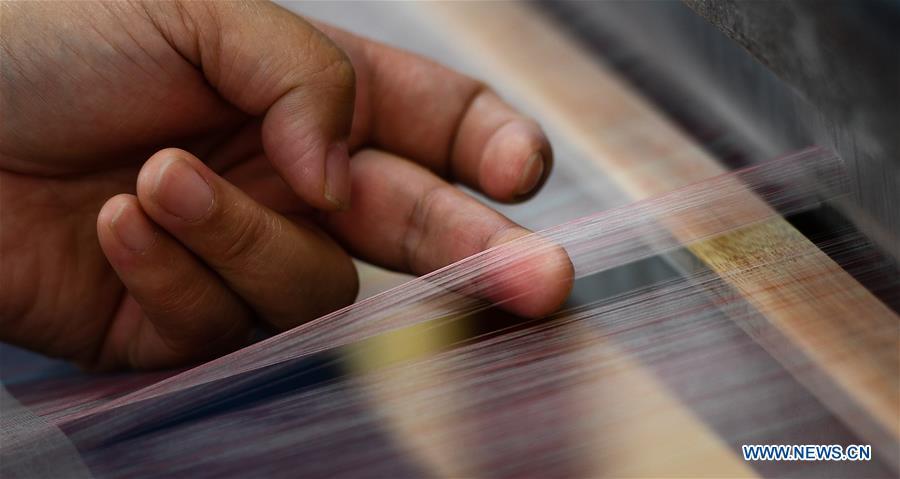 A weaver knits Yun brocade at the Nanjing Yunjin Museum in Nanjing, capital of east China\'s Jiangsu Province, Sept.26, 2018. Yunjin, also called Yun brocade, is traditional Chinese silk brocade made in Nanjing of Jiangsu. Dated from the Eastern Jin Dynasty, it has formed its own characteristics through its development of 1,600 years. Yun brocade is famous for its exquisite craft, elegant patterns and smooth texture, and the making of the artwork requires close cooperation of two weavers, who can produce only five centimeters a day. In 2009, Yun brocade was inscribed on the Representative List of the Intangible Cultural Heritage of Humanity. (Xinhua/Li Xiang)