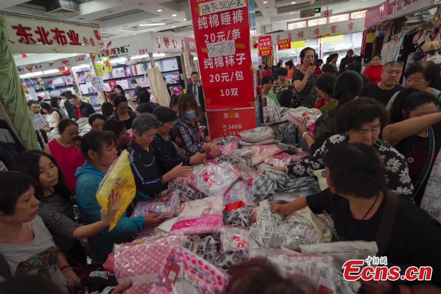 Customers purchase goods during a clearance sale at the Guanyuan Wholesale Market in Xicheng District, Beijing, Sept. 28, 2018. The market, opened in 1998, was shut down permanently on Friday as the capital continues efforts to remove non-capital functions and solve \
