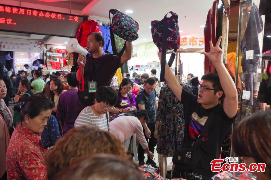 Customers purchase goods during a clearance sale at the Guanyuan Wholesale Market in Xicheng District, Beijing, Sept. 28, 2018. The market, opened in 1998, was shut down permanently on Friday as the capital continues efforts to remove non-capital functions and solve \