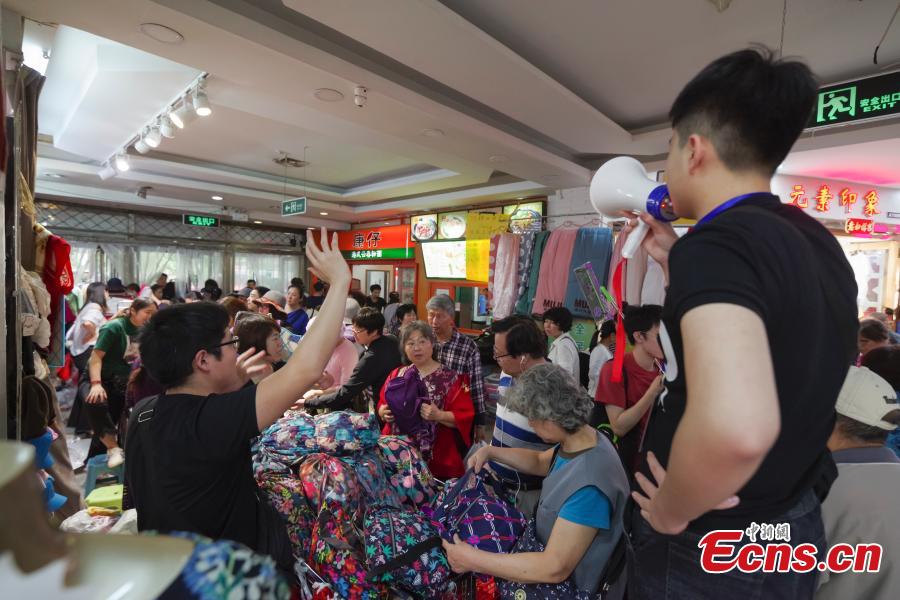 Customers purchase goods during a clearance sale at the Guanyuan Wholesale Market in Xicheng District, Beijing, Sept. 28, 2018. The market, opened in 1998, was shut down permanently on Friday as the capital continues efforts to remove non-capital functions and solve \