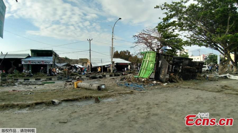 People look at the aftermath of the tsunami in Palu, on Sulawesi island on September 29, 2018. Rescuers scrambled to reach tsunami-hit central Indonesia and assess the damage after a strong quake brought down several buildings and sent locals fleeing their homes for higher ground.(Photo/Agencies)