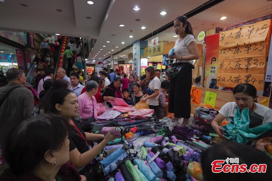 Customers purchase goods during a clearance sale at the Guanyuan Wholesale Market in Xicheng District, Beijing, Sept. 28, 2018. The market, opened in 1998, was shut down permanently on Friday as the capital continues efforts to remove non-capital functions and solve \