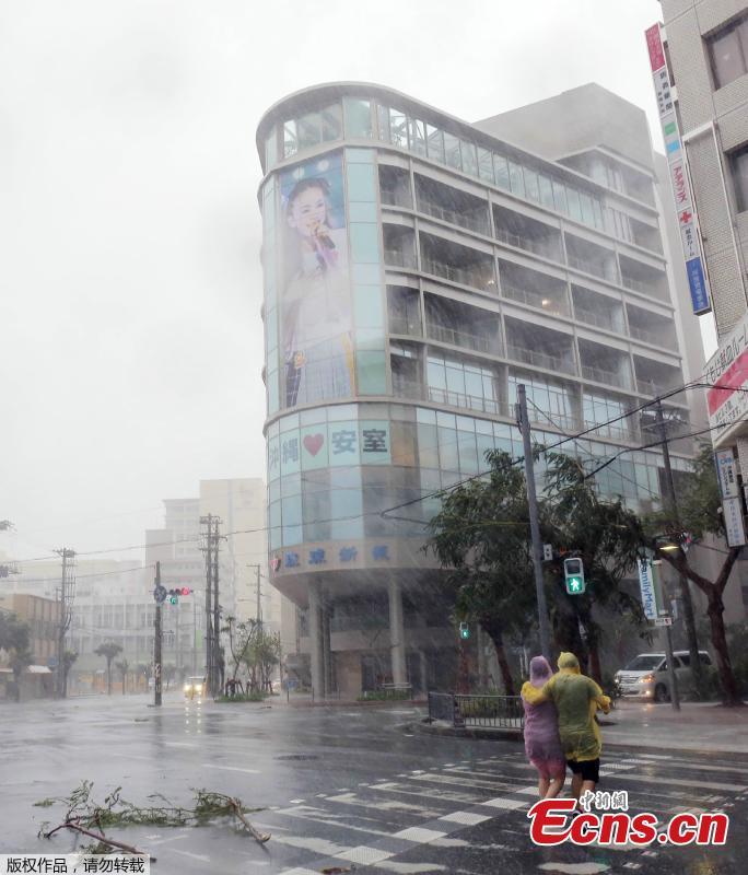 A couple crosses the street in the city center of Naha, Okinawa prefecture, Sept. 29, 2018 as the island is the first part of Japan to face the typhoon Trami. (Photo/Agencies)