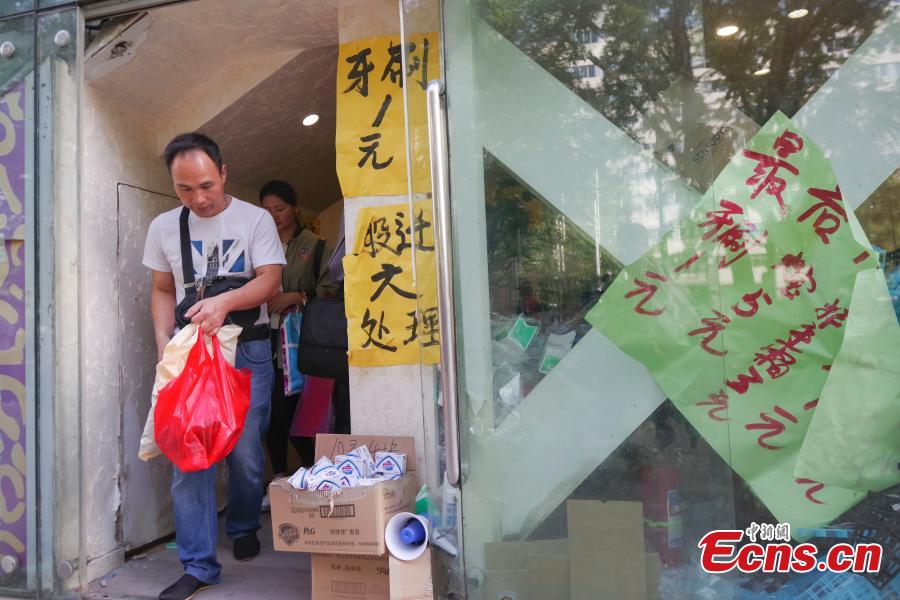 Customers purchase goods during a clearance sale at the Guanyuan Wholesale Market in Xicheng District, Beijing, Sept. 28, 2018. The market, opened in 1998, was shut down permanently on Friday as the capital continues efforts to remove non-capital functions and solve \