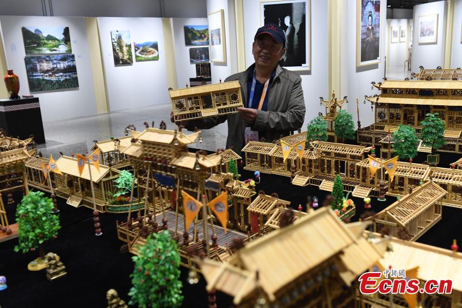 Craftsman Wu Tianxiang shows a replica of Fuxi Temple in Tianshui City made using bamboo sticks during the Silk Road (Dunhuang) International Cultural Expo in Dunhuang City, Northwest China’s Gansu Province, Sept. 28, 2018. It took Wu five years and 20,000 bamboo sticks to create the miniaturized landscape that measured 4.8 meters long and 4.2 meters wide and included 58 buildings in great details. Each door and window in the model can be opened easily. (Photo: China News Service/Yang Yanmin)