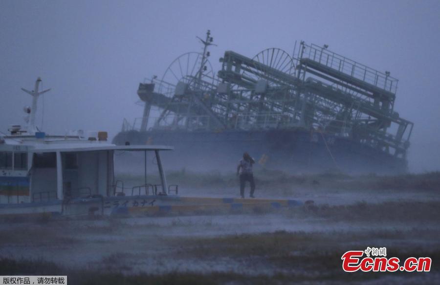 A ship (back) washes ashore at a port in Yonabaru, Okinawa Prefecture, on Sept. 29, 2018, as typhoon Trami approaches Japan\'s southernmost prefecture.  (Photo/Agencies)