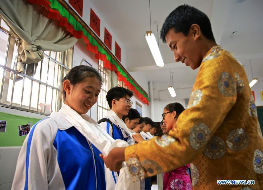 A student of the Tibetan ethnic group (R) offers hada, a ceremonial silk scarf regarded as a token of respect, to local students of the Han ethnic group in Nanchang, capital of east China\'s Jiangxi Province, Sept. 30, 2018. Some 20 students of the Tibetan ethnic group from the No. 17 Middle School celebrated China\'s National Day with local residents and students. China\'s National Day falls on Oct. 1.(Xinhua/Hu Chenhuan)