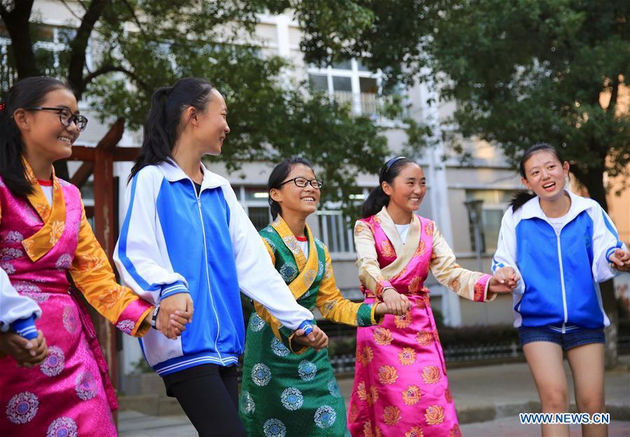 Students of the Tibetan ethnic group dance with peers of the Han ethnic group in Nanchang, capital of east China\'s Jiangxi Province, Sept. 30, 2018. Some 20 students of the Tibetan ethnic group from the No. 17 Middle School celebrated China\'s National Day with local residents and students. China\'s National Day falls on Oct. 1.(Xinhua/Hu Chenhuan)