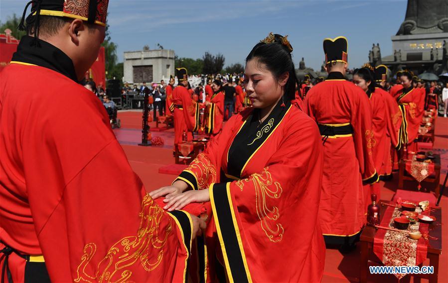 Newlyweds dressed in Han-style costumes take part in a group wedding ceremony at a square in Xi\'an, northwest China\'s Shaanxi Province, Oct. 1, 2018. A total of 30 pairs of newlyweds attended the wedding on Monday. (Xinhua/Liu Xiao)