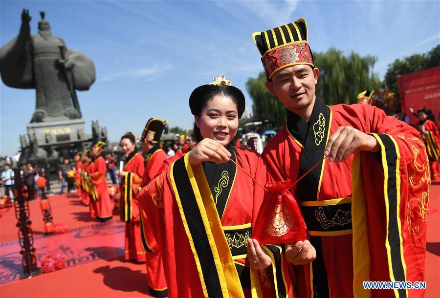 Newlyweds dressed in Han-style costumes take part in a group wedding ceremony at a square in Xi\'an, northwest China\'s Shaanxi Province, Oct. 1, 2018. A total of 30 pairs of newlyweds attended the wedding on Monday. (Xinhua/Liu Xiao)