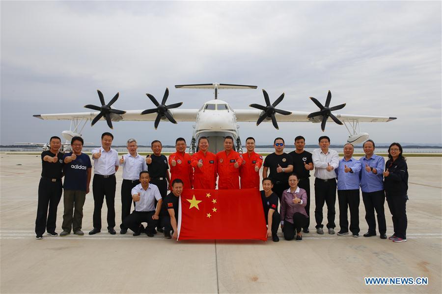 The crew and staff workers pose for photos after the first high-speed taxiing test on water of AG600, China\'s independently-developed large amphibious aircraft, in Jingmen, central China\'s Hubei Province, Oct. 1, 2018. The AG600 has successfully completed the high-speed taxiing test on water Monday. (Xinhua/Photo provided by Aviation Industry Corporation of China, Ltd.)