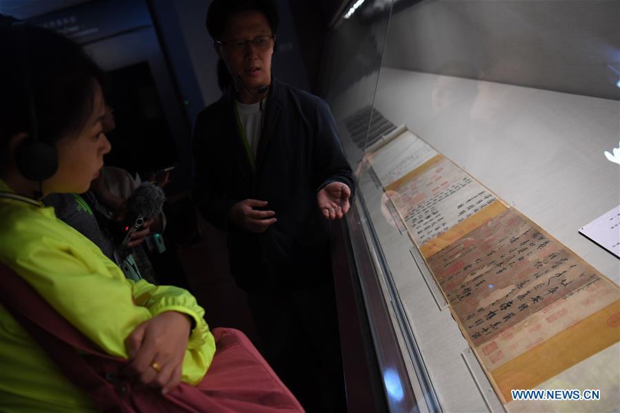 A staff worker introduces a calligraphy work of Wang Xizhi at the palace museum in Taipei, southeast China\'s Taiwan, Oct. 3, 2018. The museum will hold an exhibition under the title of \