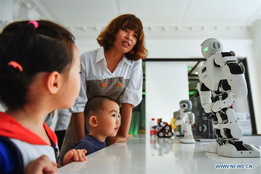 Children watch the robots displayed at the Beijing Design Week in Beijing, capital of China, Oct. 4, 2018. The Beijing Design Week, a platform aimed at promoting the concept of a sustainable development of creative and design industry, last from Sept. 22 to Oct. 7. (Xinhua/Li Mangmang)
