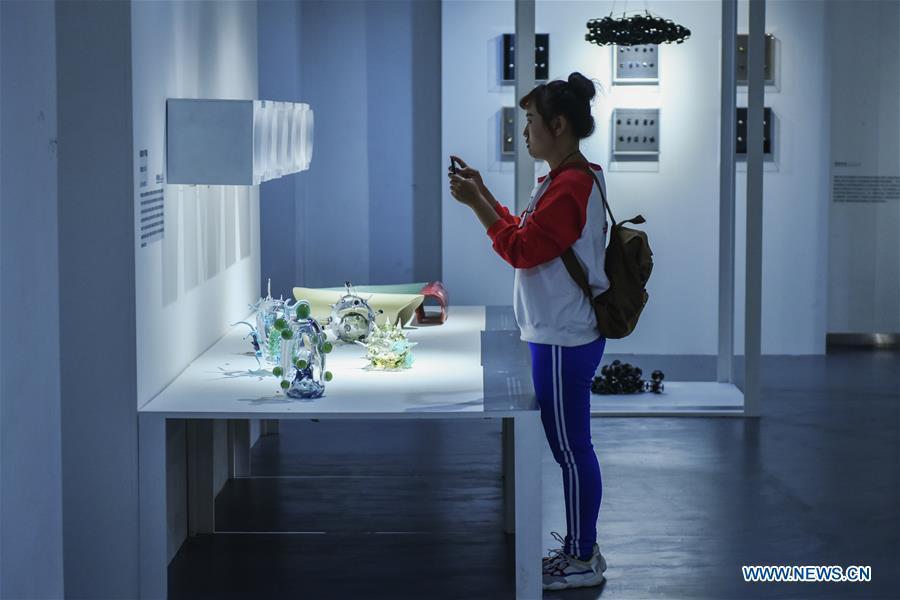 A visitor takes photos of art works displayed at the Beijing Design Week in Beijing, capital of China, Oct. 4, 2018. The Beijing Design Week, a platform aimed at promoting the concept of a sustainable development of creative and design industry, last from Sept. 22 to Oct. 7. (Xinhua/Li Mangmang)