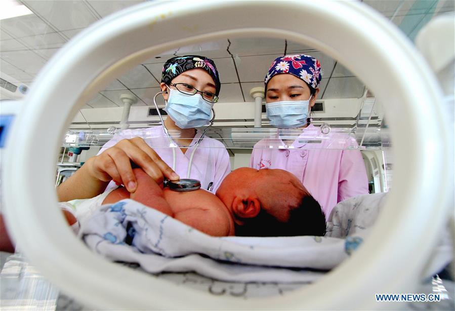 Nurses check a new-born at Wu\'an First People\'s Hospital in Wu\'an, north China\'s Hebei Province, Oct. 4, 2018. People from various sectors stick to their posts during the National Day holiday. (Xinhua/Wang Xiao)