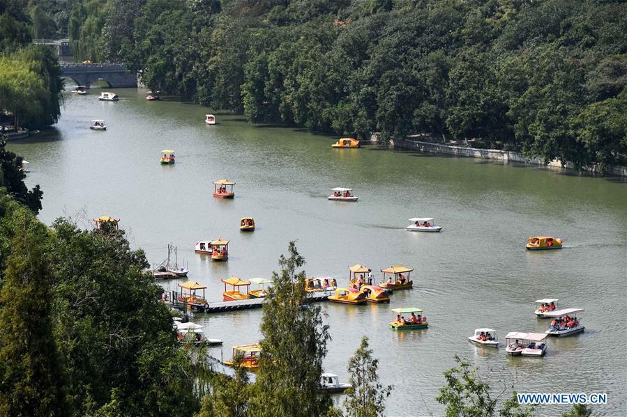 Tourists view the scenery by boat at Bao Gong Garden, a scenic spot constructed in memory of Bao Zheng, a righteous government officer of ancient China\'s Song Dynasty (960-1279), during the week-long National Day holiday in Hefei, east China\'s Anhui Province, Oct. 5, 2018. (Xinhua/Zhang Duan)