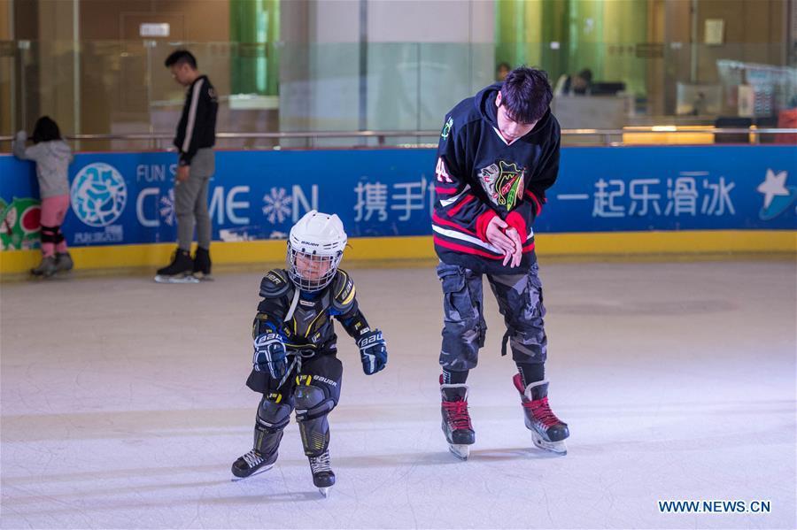 A coach instructs a child in skating at an ice rink during the week-long National Day holiday in Kunming, capital of southwest China\'s Yunnan Province, Oct. 5, 2018. (Xinhua/Hu Chao)