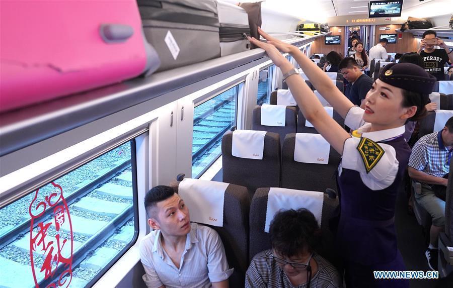 Li Xiaojia, conductor of train G99, arranges the luggage at Hongqiao Railway Station in Shanghai, east China, Sept. 23, 2018. Train G99, the first high-speed train from Shanghai to Hong Kong, left Hongqiao Station on Sept. 23 for Hong Kong West Kowloon Station. (Xinhua/Chen Fei)