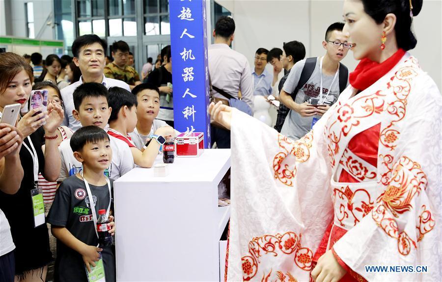 Visitors view a humanoid at China International Robot Show (CiROS) 2018 in east China\'s Shanghai, July 4, 2018. (Xinhua/Fang Zhe)