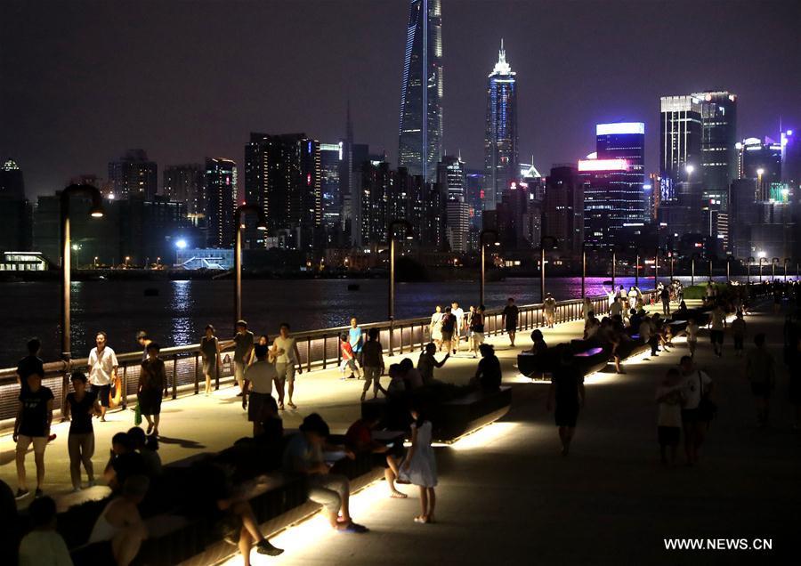 People walk on the riverside avenue by the Huangpu River in Shanghai, east China, July 10, 2017. (Xinhua/Chen Fei)