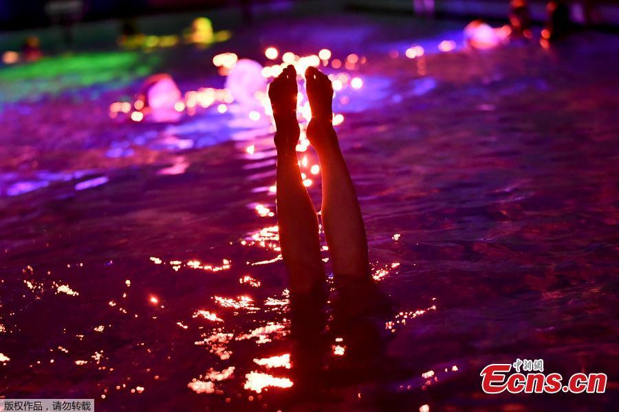 People swim in the lighted water of the Hirschengraben indoor swimming pool in Bern during an artistic performance by Swiss visual artist Pipilotti Rist and World Wide Fund for Nature (WWF) Switzerland non-governmental organization to denounce the disappearance of corals due to the warming and the acidification of the ocean on October 7, 2018.  (Photo/Agencies)