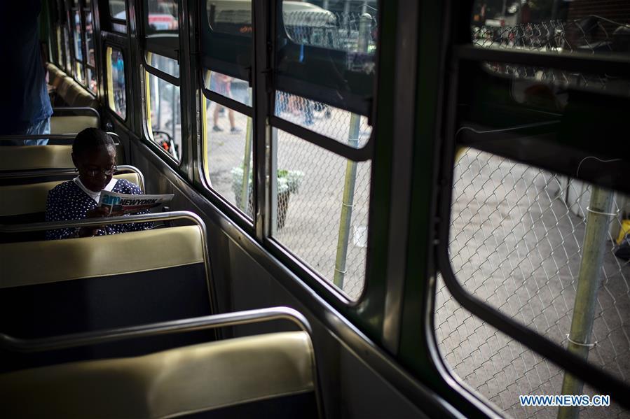 A man looks at a vintage bus during the 25th Annual Bus Festival in New York, the United States, on Oct. 7, 2018. The New York Transit Museum held its 25th annual bus festival on Sunday. The buses on display represent about 80 years of surface transit history in New York City. The oldest bus at the festival, Bus 1263, is a double-decker bus that was purchased by the Fifth Avenue Bus Company in 1930. (Xinhua/Li Muzi)
