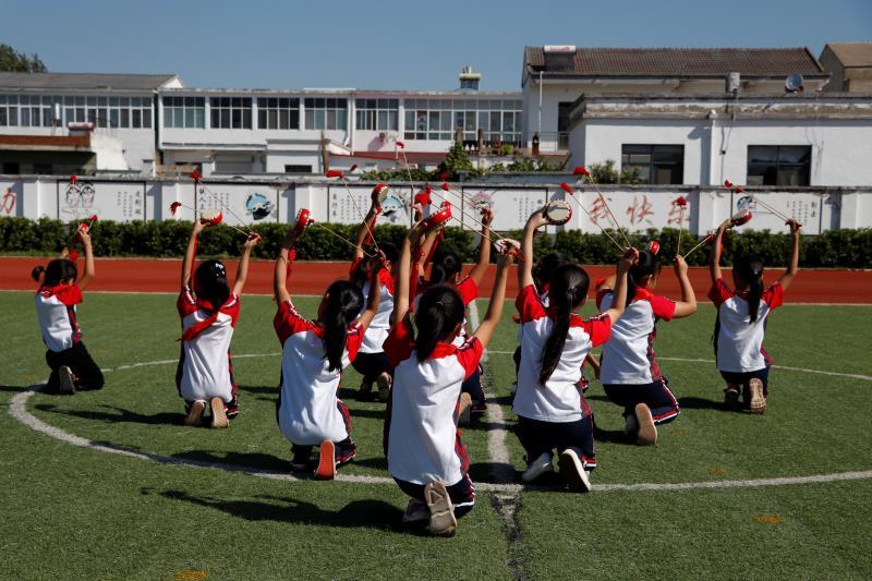 A group of primary school students perform the Fengyang Flower-drum Dance during a break between classes on Sept. 27. Popular in Fengyang county, which governs Xiaogang village, the dance has a history of more than 600 years. (Photo/chinadaily.com.cn)