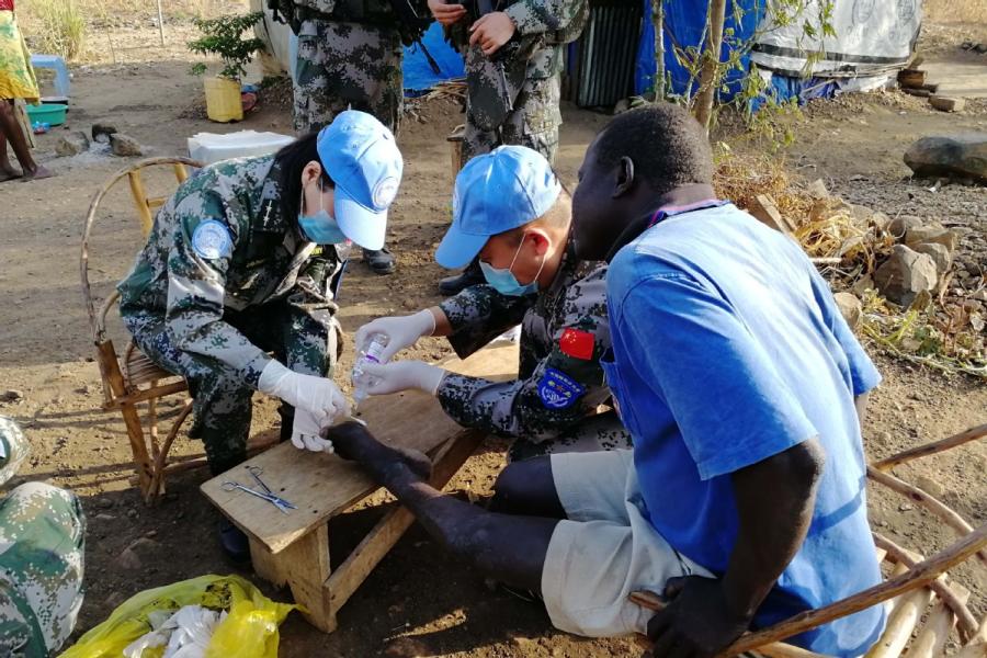 Chinese peacekeepers provide medical care to people in Juba, South Sudan. (Photo/CHINA DAILY)

Growing contribution to UN missions ensures stable development

Loud cheers fill the sweltering air in Juba, capital of South Sudan.

It is Aug. 1, Army Day, when China celebrates the founding of the People\'s Liberation Army in 1927, and soldiers of the Chinese Peacekeeping Infantry Battalion are commemorating the event.

With colleagues cheering wildly on the sidelines, competitors in a relay race involving battalion members pass the baton, heedless of the scorching sun, and the support company eventually wins the day.

For more than a decade, China has been playing a bigger role in protecting global peace. This is the fourth group of infantry soldiers drawn from the 83rd Combined Corps of the PLA.

Under the United Nations Mission in South Sudan, they are assigned to protect local civilians and UN personnel and humanitarian assistance staff members, patrol defense areas, secure the UN compound, enforce a weapon-free zone and escort humanitarian assistance to areas under their jurisdiction.

They also have safely evacuated UN personnel during emergencies. On average, 506 troops have been deployed daily, along with 73 vehicles and hundreds of weapons.

The 700-strong battalion, consisting of infantry and artillery personnel, scouts and engineers, arrived in four groups in November. It is nearing the end of its mission.

\