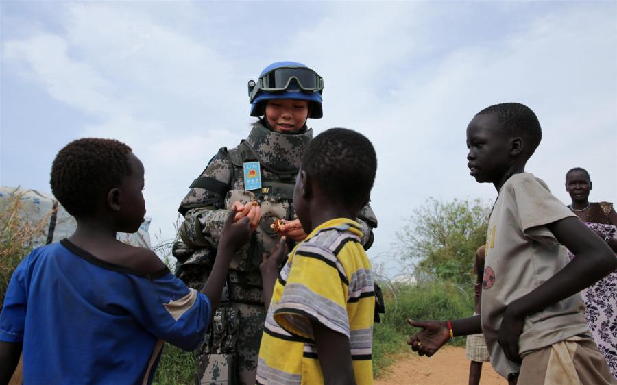 Jia Xiaochen, a Chinese peacekeeper in the infantry squad shares candy with children in Juba. (Photo/Xinhua)

Growing stature

Joining the battalion at its camp during the Army Day celebrations, the deputy head of UNMISS, Moustapha Soumare, said the presence of Chinese peacekeepers was reassuring, given the complex situation and volatility in South Sudan.

\
