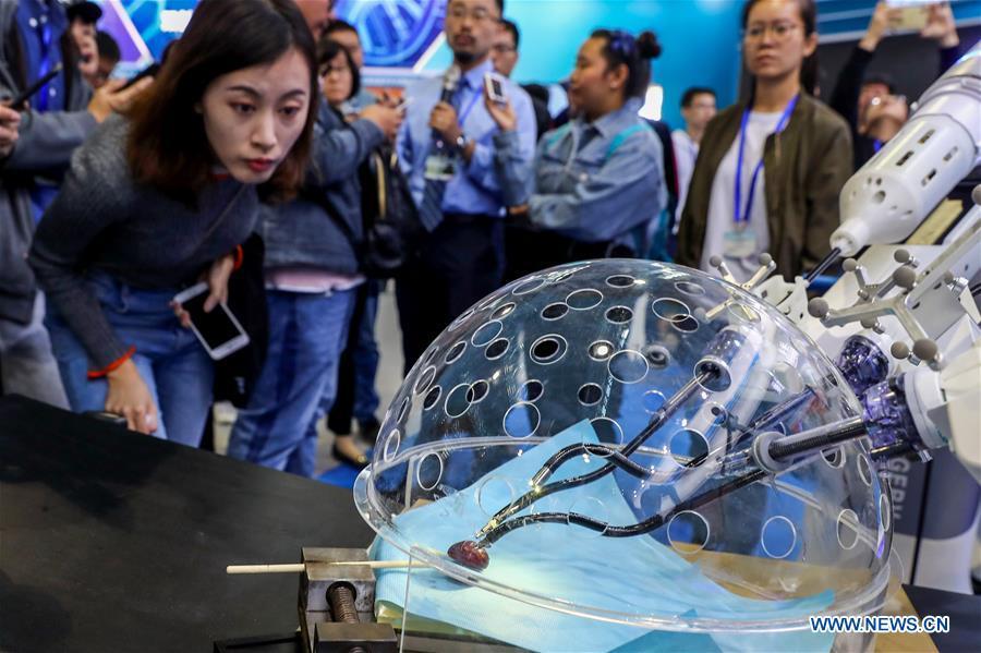 Members of the press look at a porotic laparoscopic surgery robot system during a press preview of the 2018 National Mass Innovation and Entrepreneurship Week in Beijing, capital of China, Oct. 8, 2018. The weekly event will run from October 9 to 15. (Xinhua/Zhang Yuwei)