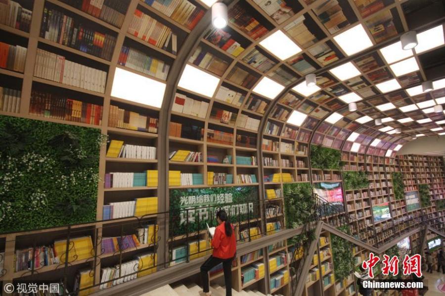 Tens of thousands of books are placed on shelves to form a 10-meter-tall books wall inside a shopping center in Chongqing, Oct. 10, 2018. (Photo/VCG)