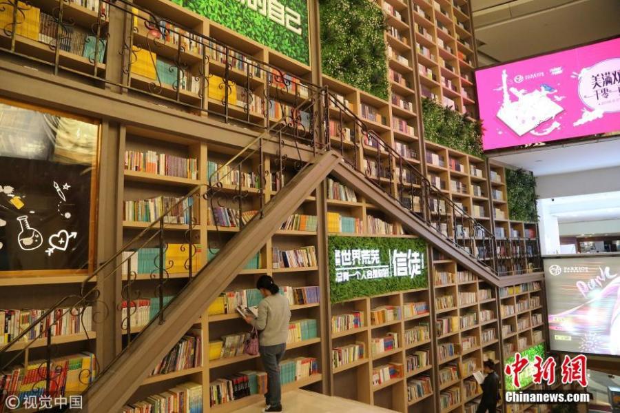 Tens of thousands of books are placed on shelves to form a 10-meter-tall books wall inside a shopping center in Chongqing, Oct. 10, 2018. (Photo/VCG)