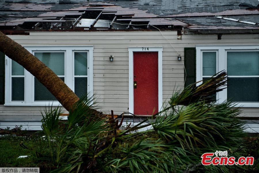 A house is seen with damage to its roof and downed trees during Hurricane Michael October 10, 2018 in Panama City, Florida. Michael slammed into the Florida coast on October 10 as the most powerful storm to hit the southern US state in more than a century as officials warned it could wreak \