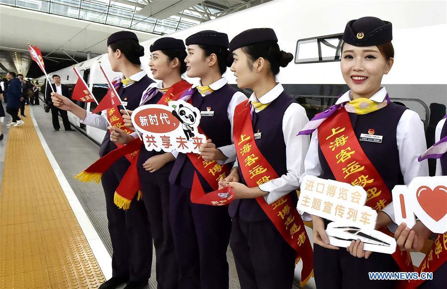 Attendants of the G2 bullet train hold sign boards to promote the first China International Import Expo (CIIE) at Hongqiao Railway Station in east China\'s Shanghai, Oct. 10, 2018. Railway authorities have launched a campaign on Wednesday to promote the upcoming first CIIE on bullet trains running on the Beijing-Shanghai high-speed railway. (Xinhua/Chen Fei)