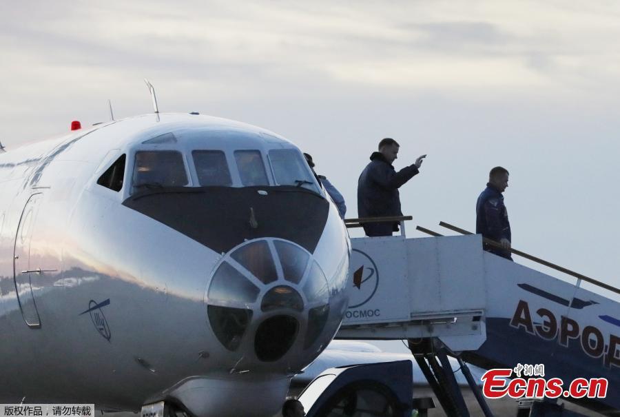 Russian cosmonaut Alexey Ovchinin (R) and U.S. astronaut Nick Hague disembark from a plane, after the \