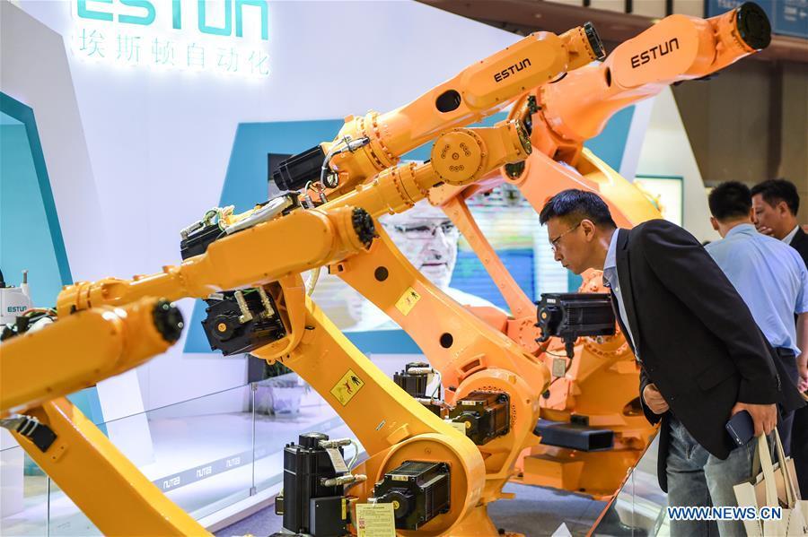 A visitor looks at an automatic robot during the World Intelligent Manufacturing Summit (WIMS) 2018 in Nanjing, east China\'s Jiangsu Province, Oct. 11, 2018. The WIMS 2018 opened at the Nanjing International Expo Center on Thursday. The event attracts over 1,900 exhibitors worldwide to showcase the latest technologies, advanced products, development trends and cutting-edge solutions in the intelligent manufacturing field. (Xinhua/Li Bo)