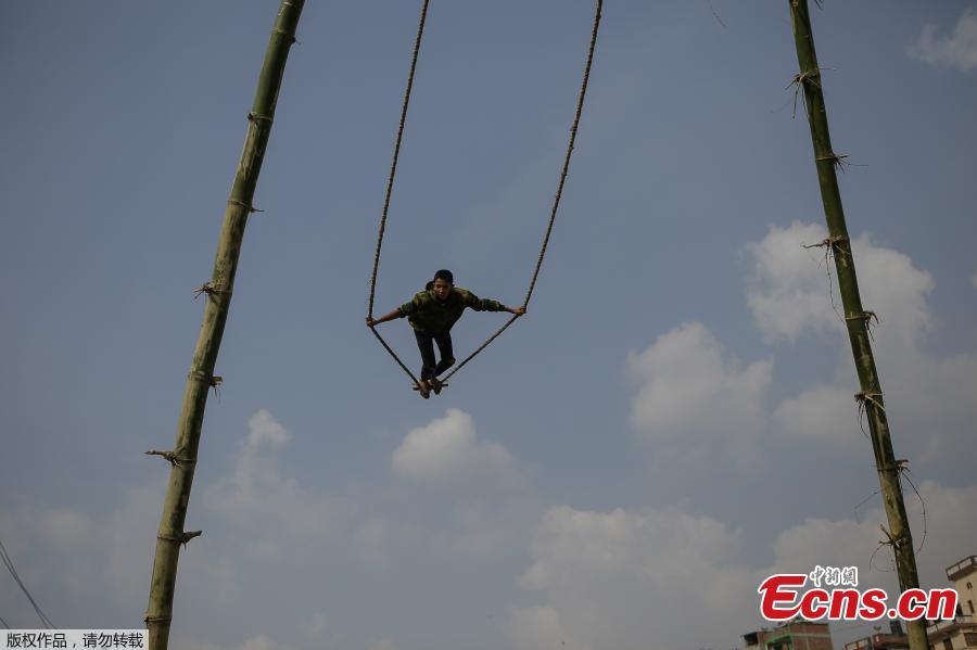 A child plays on a swing, popularly known as the \'Dashain Ping\', ahead of the Hindu festival of Dashain in Kathmandu, Nepal, Oct. 11, 2018. People of all ages often play on a swing in towns and villages during the celiebration of the festival. (Photo: China News Service/Pu Ladan)