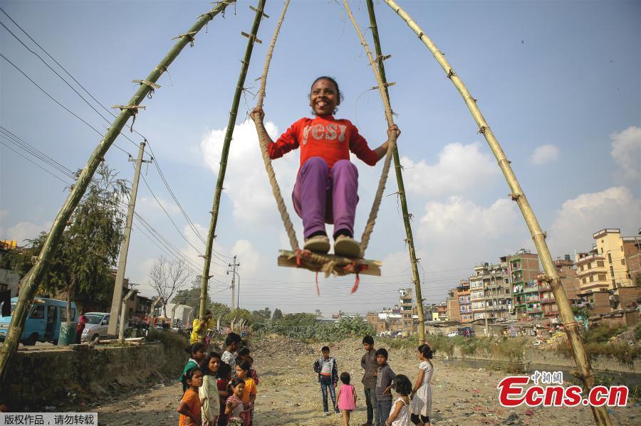 A child plays on a swing, popularly known as the \'Dashain Ping\', ahead of the Hindu festival of Dashain in Kathmandu, Nepal, Oct. 11, 2018. People of all ages often play on a swing in towns and villages during the celiebration of the festival. (Photo: China News Service/Pu Ladan)
