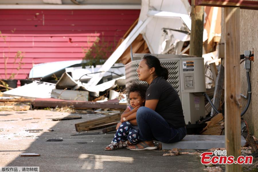 Wimlin Washington and her 3-year-old daughter Mia sit in front of their restaurant, damaged by Hurricane Michael in Callaway, Florida, U.S. October 11, 2018. (Photo/Agencies)