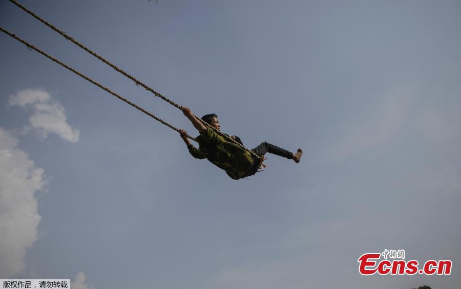 A child plays on a swing, popularly known as the \'Dashain Ping\', ahead of the Hindu festival of Dashain in Kathmandu, Nepal, Oct. 11, 2018. People of all ages often play on a swing in towns and villages during the celiebration of the festival. (Photo: China News Service/Pu Ladan)
