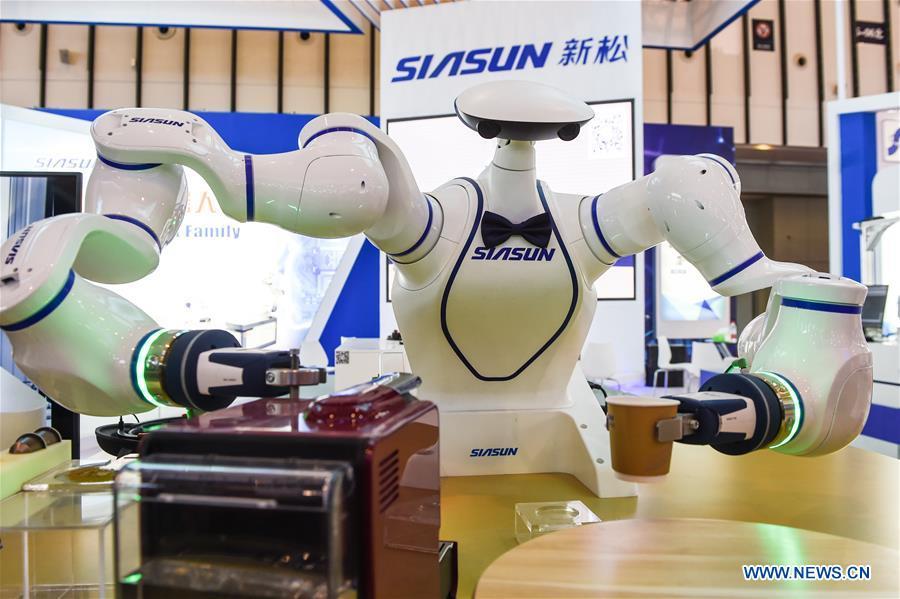 A dual-arm assistant robot makes coffee during the World Intelligent Manufacturing Summit (WIMS) 2018 in Nanjing, east China\'s Jiangsu Province, Oct. 11, 2018. The WIMS 2018 opened at the Nanjing International Expo Center on Thursday. The event attracts over 1,900 exhibitors worldwide to showcase the latest technologies, advanced products, development trends and cutting-edge solutions in the intelligent manufacturing field. (Xinhua/Li Bo)