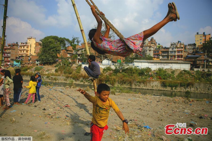 A child plays on a swing, popularly known as the \'Dashain Ping\', ahead of the Hindu festival of Dashain in Kathmandu, Nepal, Oct. 11, 2018. People of all ages often play on a swing in towns and villages during the celiebration of the festival. (Photo: China News Service/Pu Ladan)