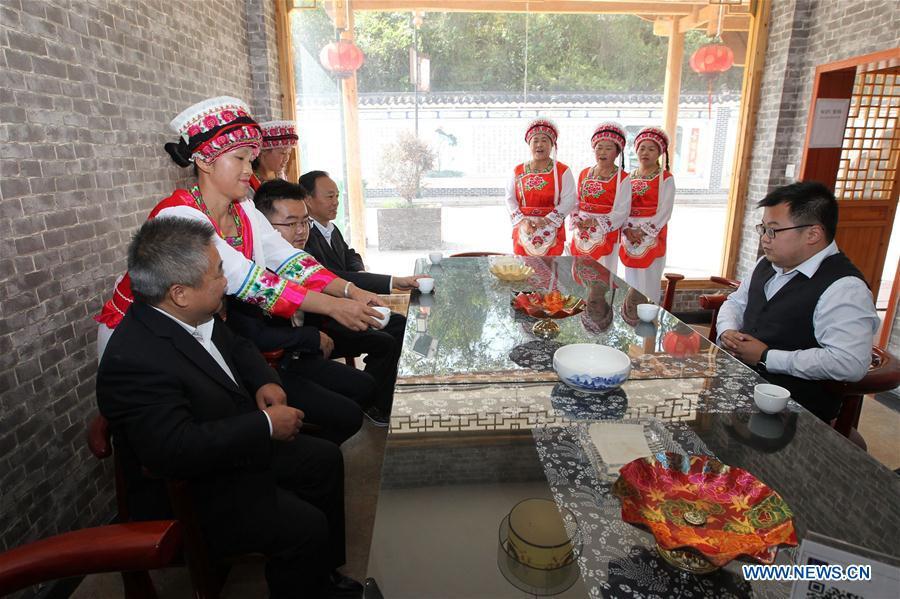 Women of Bai ethnic group serve tea to guests at a tea house at the Suoziqiu Village of Mahekou Township in Sangzhi County of Zhangjiajie City, central China\'s Hunan Province, Oct. 11, 2018. People of the Bai ethnic group here still follow the welcoming tradition of their immigrated ancestors to offer \