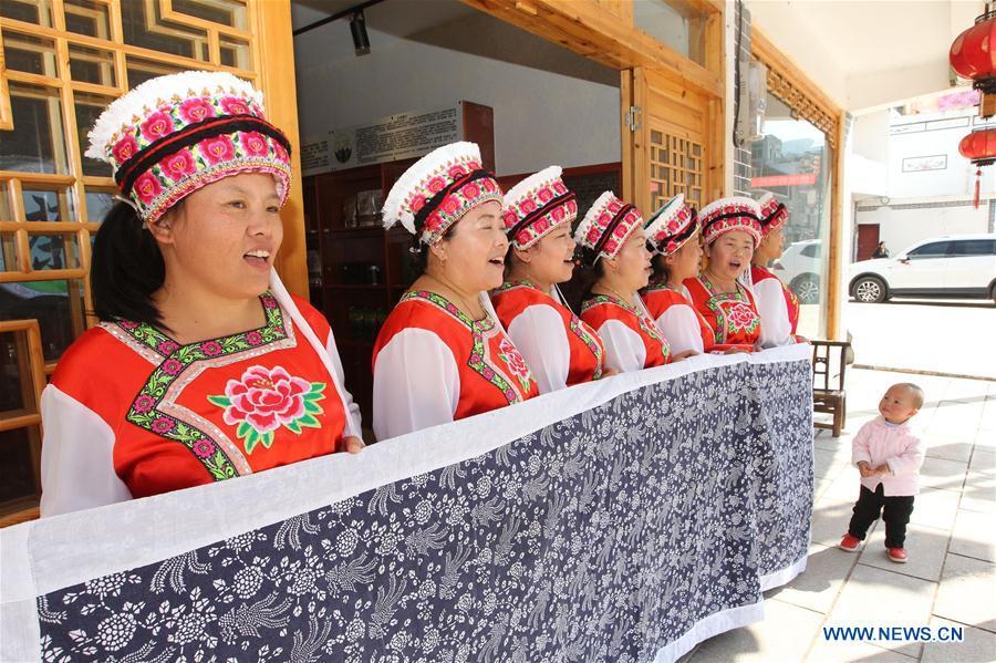 Women of Bai ethnic group sing a welcoming song for guests at the door of a tea house at the Suoziqiu Village of Mahekou Township in Sangzhi County of Zhangjiajie City, central China\'s Hunan Province, Oct. 11, 2018. People of the Bai ethnic group here still follow the welcoming tradition of their immigrated ancestors to offer \