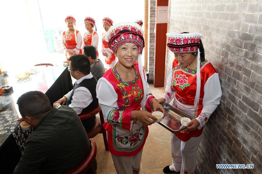 Women of Bai ethnic group serve tea to guests at a tea house at the Suoziqiu Village of Mahekou Township in Sangzhi County of Zhangjiajie City, central China\'s Hunan Province, Oct. 11, 2018. People of the Bai ethnic group here still follow the welcoming tradition of their immigrated ancestors to offer \