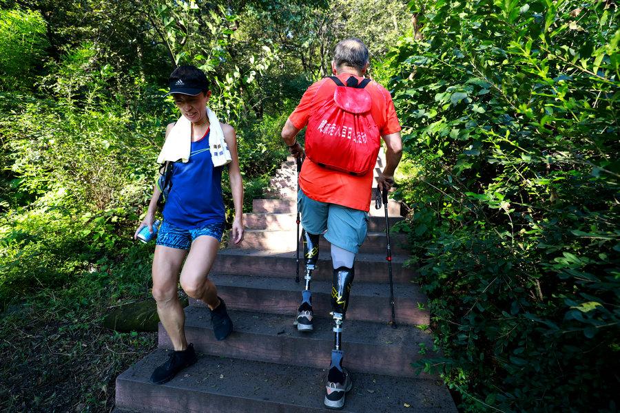 A brush with a mountaineer in Xiangshan Park. (Photo/China Daily)

He says that as he has no ankle joints - with both his legs amputated below the knees - and depends on his prosthetic limbs it is easy to slip and fall.

In 1975, Xia Boyu attempted to scale Qomolangma for the first time as a member of the Chinese mountaineering team, and encountered a blizzard. Then, his feet were frostbitten and his legs were amputated.